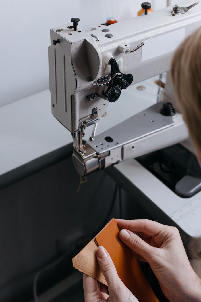 Person skillfully handling fabric with a sewing machine, showcasing textile craftsmanship.